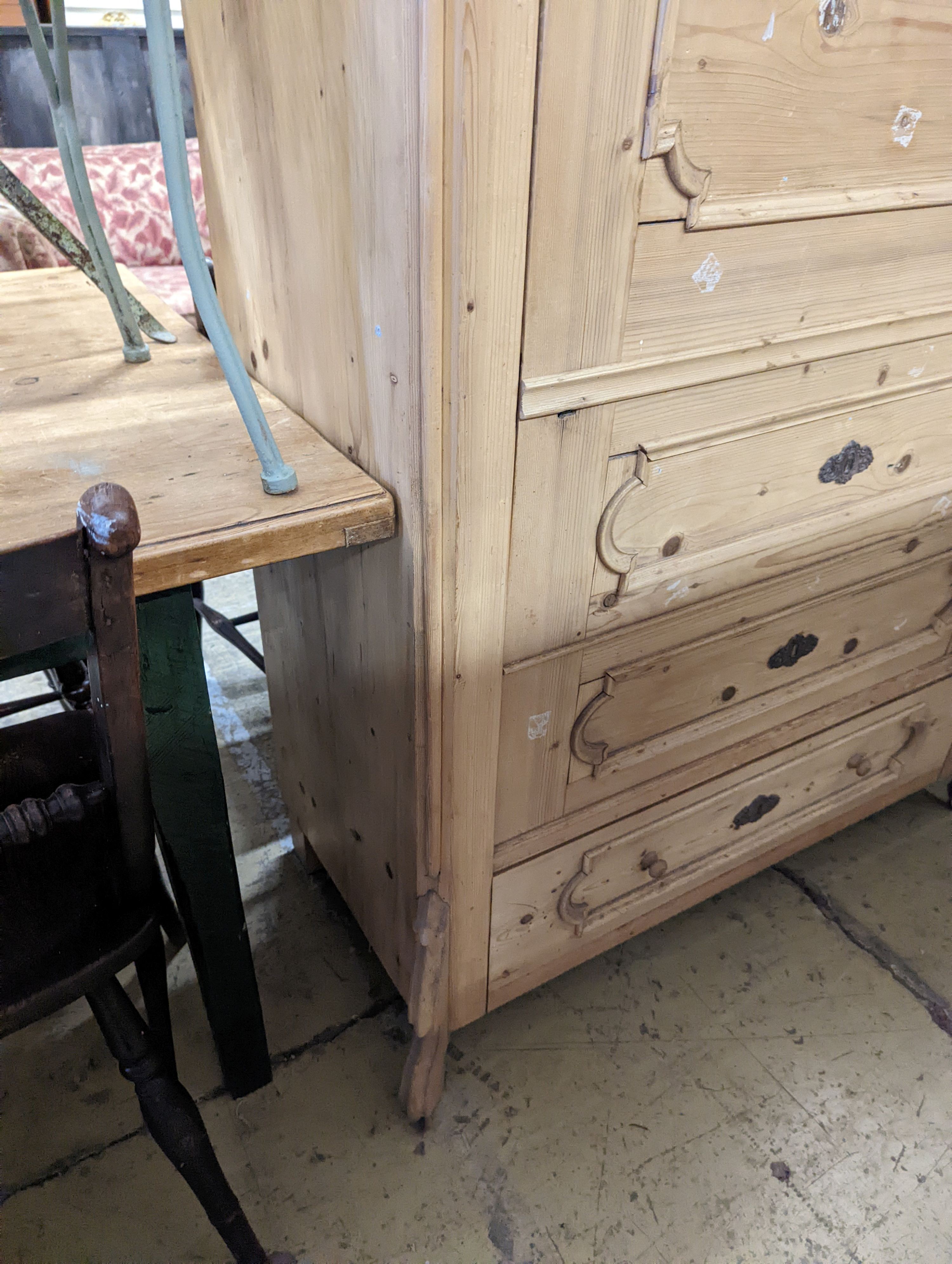 A 19th century Continental pale pine hanging cupboard with dummy drawer front, width 104cm, depth 50cm, height 183cm